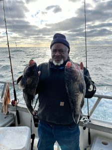 a man holding a fish on a boat