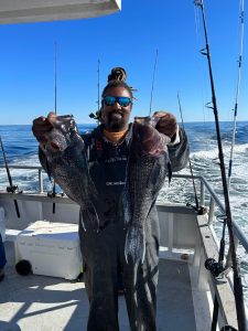 a man holding a fish on a boat