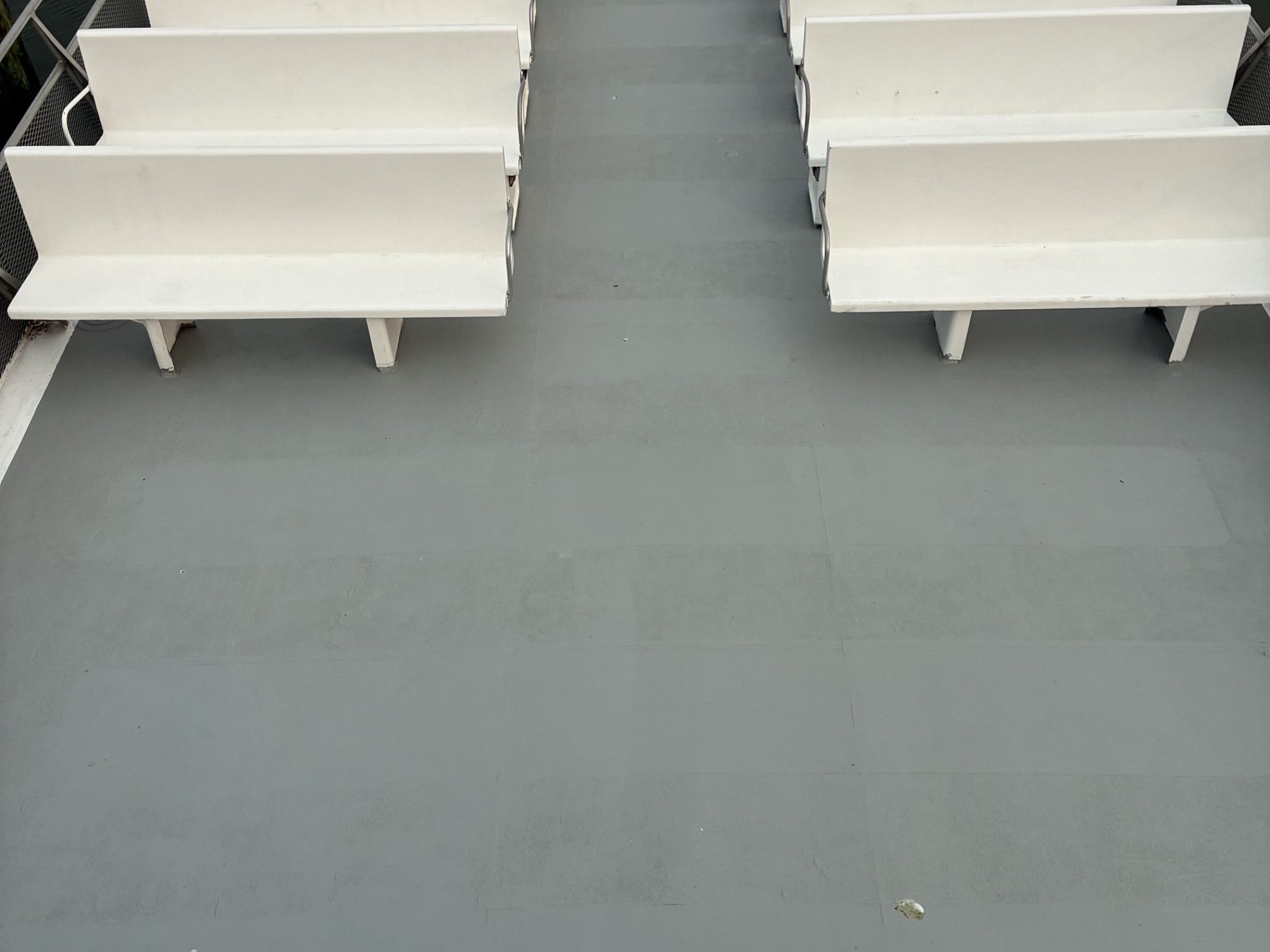 Two rows of white stadium-style seats on a gray floor.