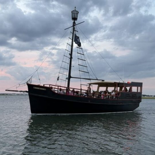 Inverted image of a boat on a calm body of water at sunset.